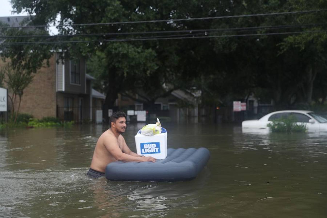 Un hombre utiliza una colchoneta para transportar sus pertenencias. 