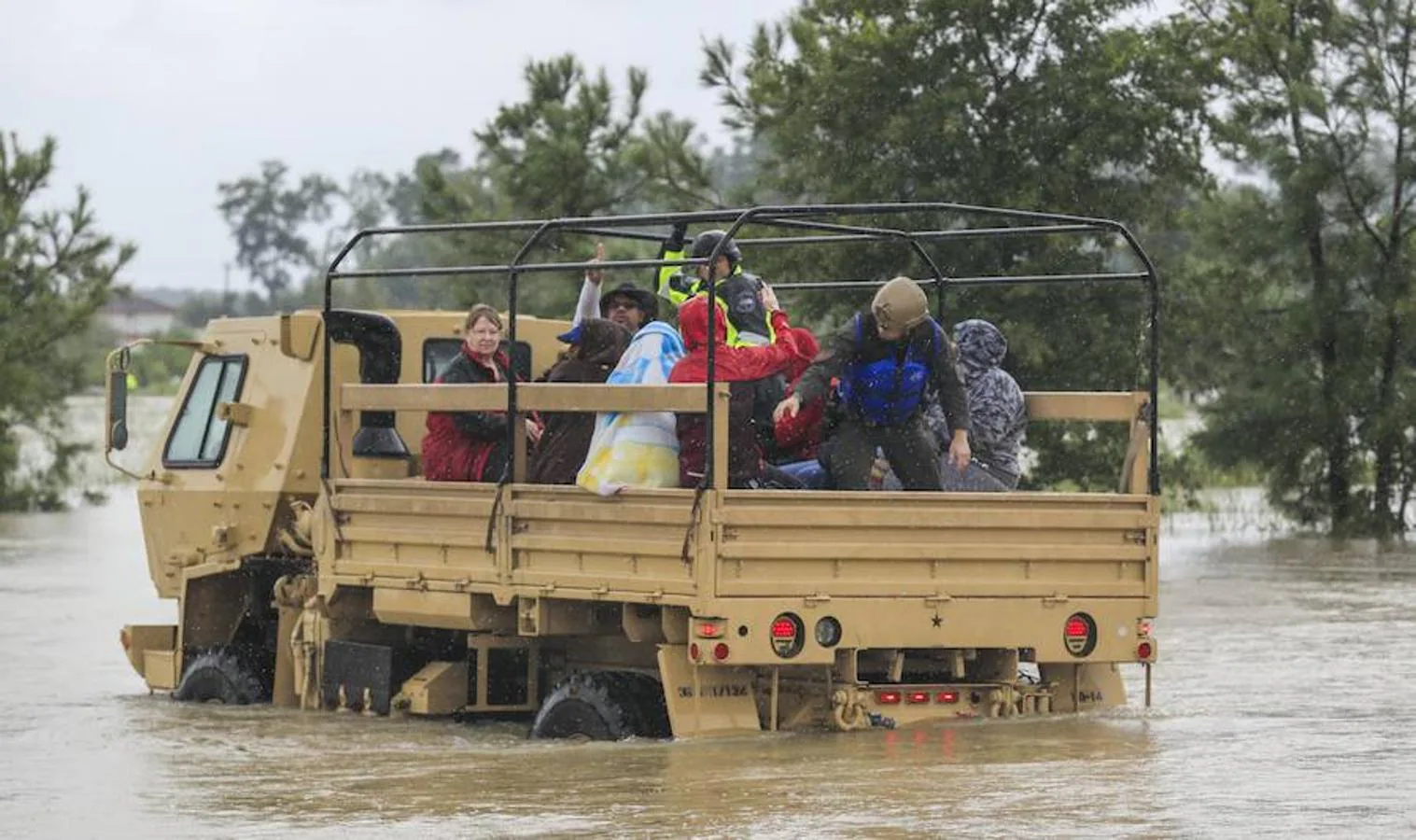 Camiones de la Guardia Nacional de Texas llevan a personas afectadas por las inundaciones y vehículos sumergidos después del huracán Harvey en Houston, Texas, Estados Unidos, 29 de agost. 