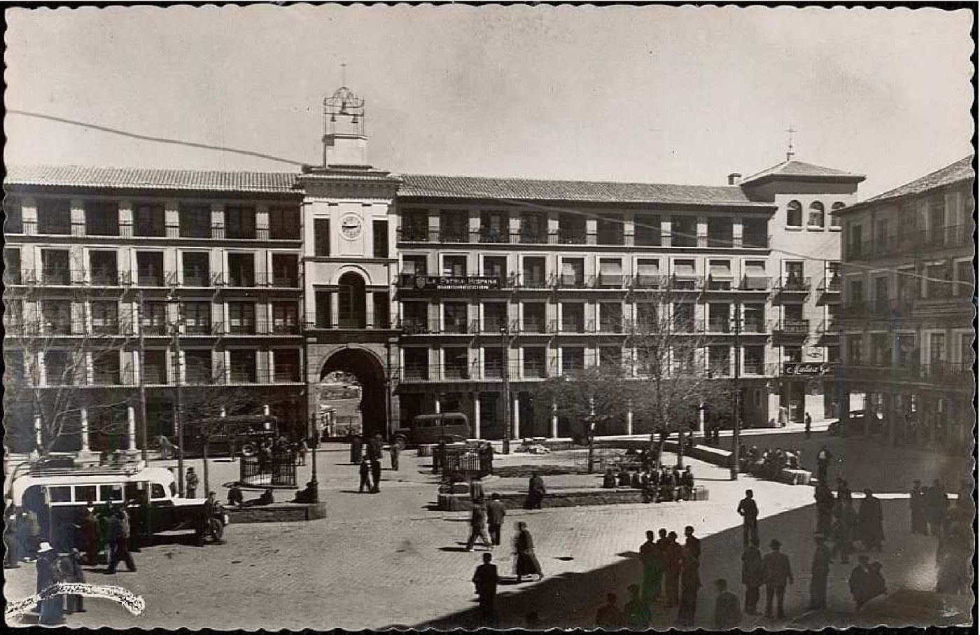 Fachada del Arco de la Sangre y aspecto de la plaza en torno a 1955 con el paseo central creado en 1926. Colección Archivo Municipal de Toledo. 