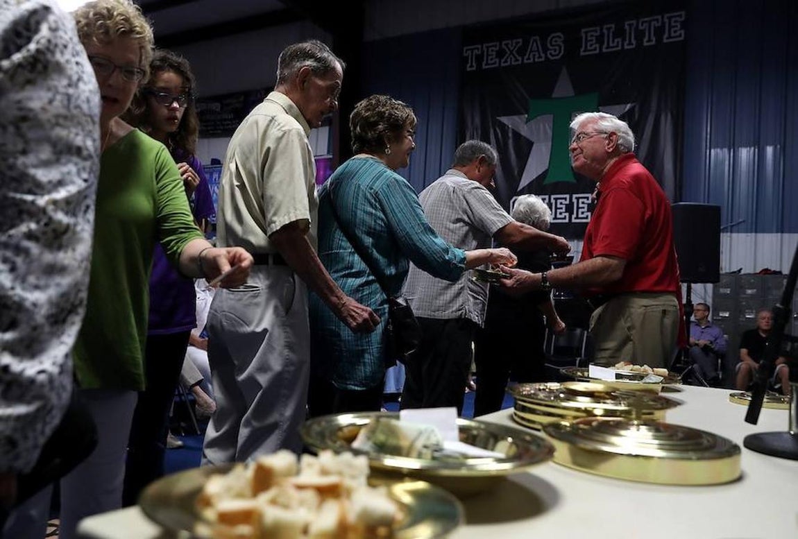 Comunión. Miembros de la comunidad cristiana de la Iglesia Cypress Creek hacen cola para recibir la Comunión durdante los servicios del domingo llevados a cabo en el polideportivo Basel's Gymnastics