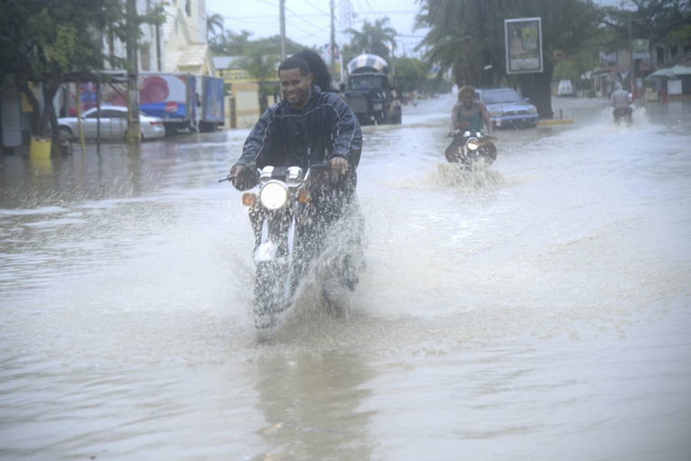 Un motociclista pasa por una calle inundada en Villa Vásquez, provincia de Monti Cristi (República Dominicana). 