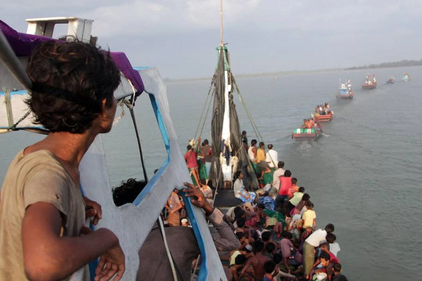 Barcos de pescadores remolcan otra nave repleta de inmigrantes rohingyas frente a la costa de Geulumpang, en Indonesia.. 