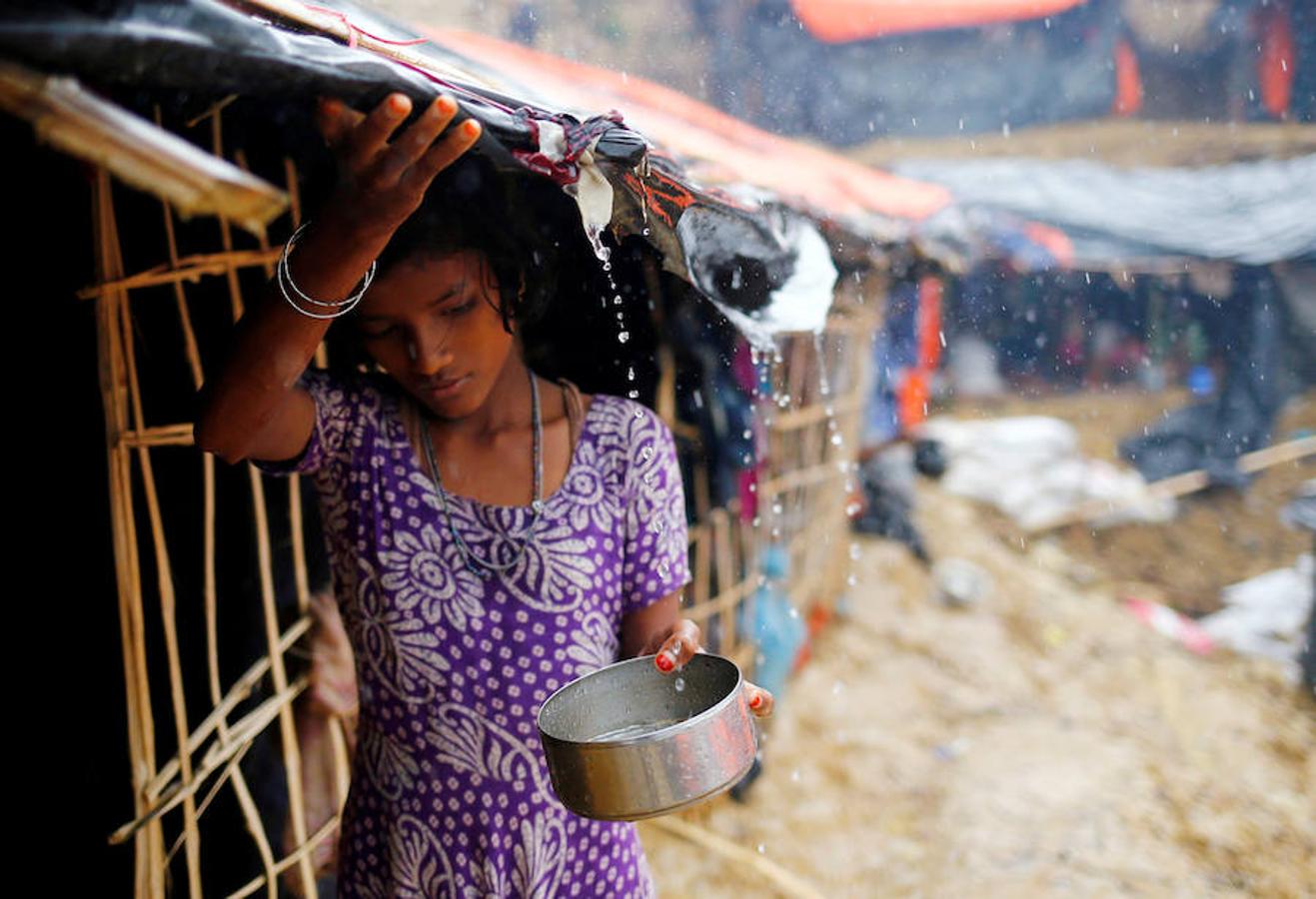 Una muchacha rohingya recolecta agua de lluvia en un campo de refugiados de Bangladesh.. 