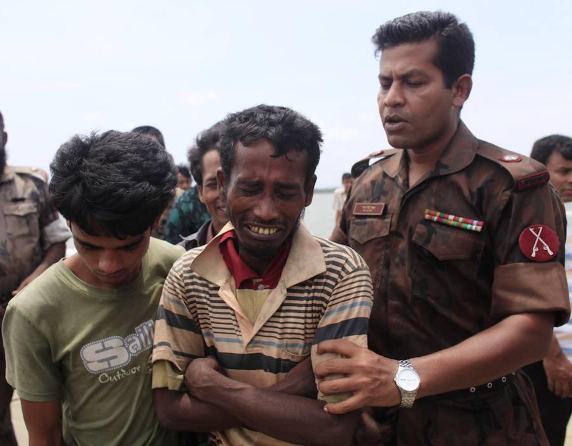 Un miembro de la Policía fronteriza bangladesí trata de consolar a un birmano rohingya, arrestado al intentar cruzar la frontera para huir de su país.. 