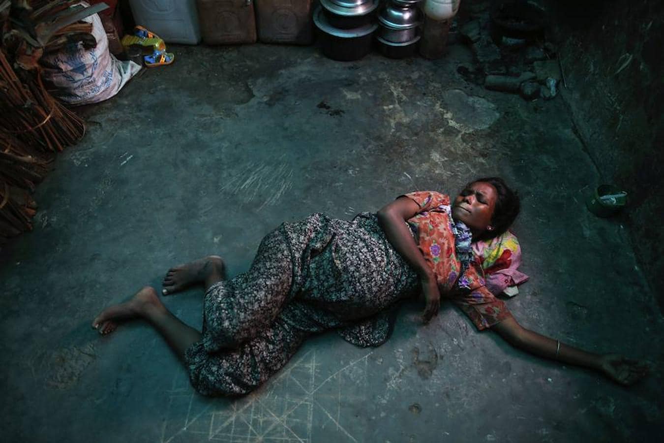 Roma Hattu, una rohingya embarazada de nueve meses, se retuerce en el suelo de una antigua fábrica birmana –ahora refugio para familias de esta minoría étnica– por los dolores del parto.. 