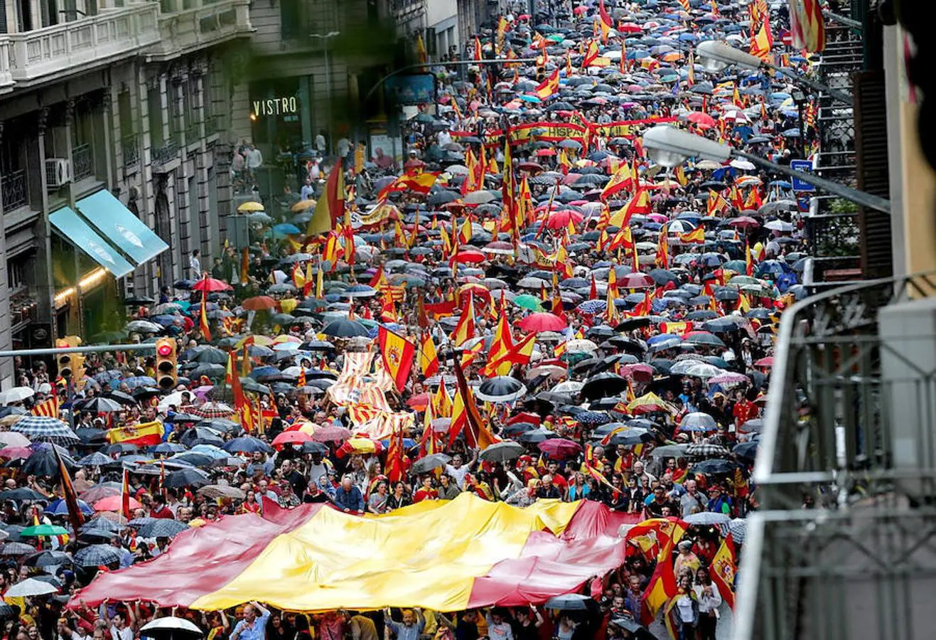 Varios participantes portan la bandera española durante la manifestación convocada por Movimiento Cívico de España y Catalanes, hoy por la Vía Layetana, en Barcelona, con el lema «Catalunya es Espanya. Democracia, futuro y libertad».. 