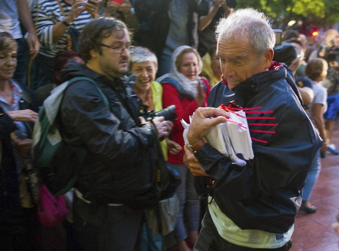 Personas entrando a los colegios con las papeletas y las urnas. 