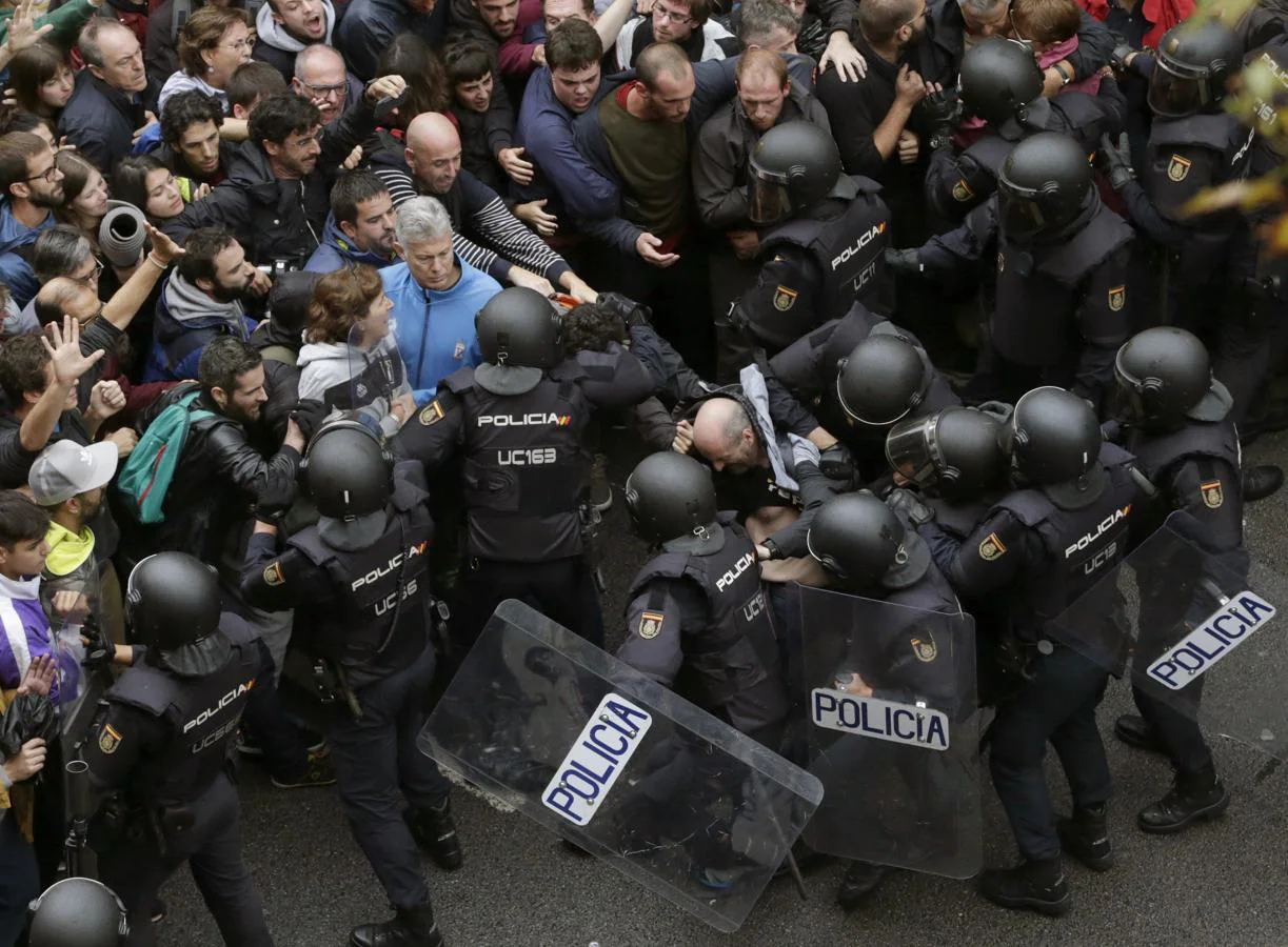 Agentes antidisturbios de la Policía Nacional forman un cordón de seguridad frente al colegio Ramón Llull de Barcelona. 