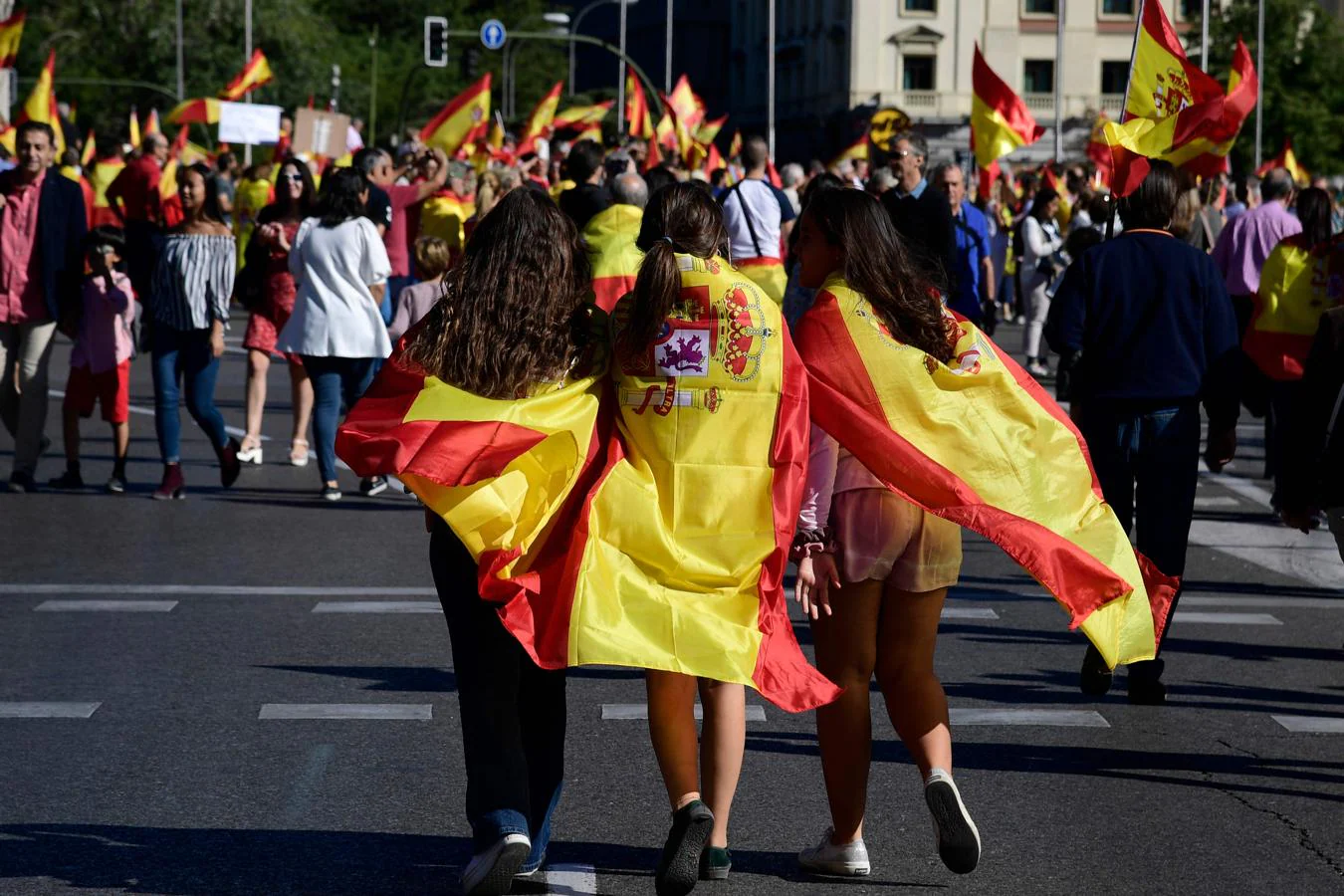 Grupo de jóvenes portando la bandera española en Madrid. 
