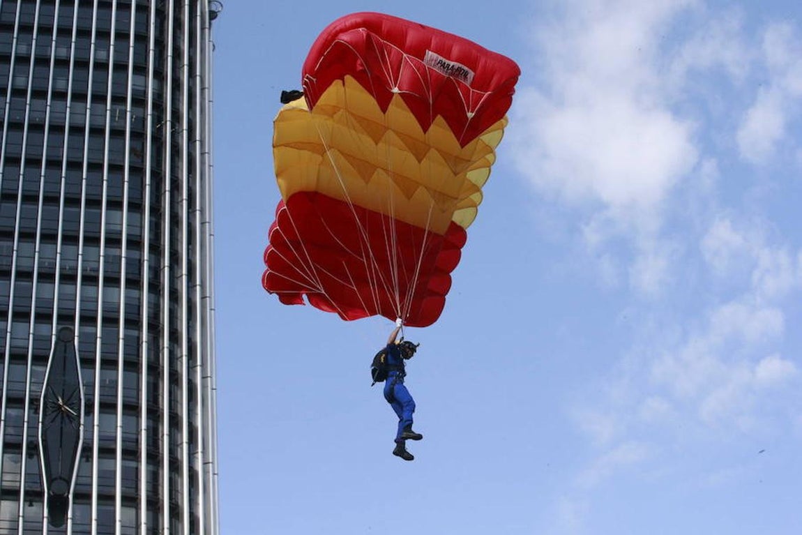 Un paracaidista desciende hasta el asfalto del Paseo de la Castellana al inicio del desfile del Día de la Fiesta Nacional que ha sido presidido hoy por los Reyes (EFE). 