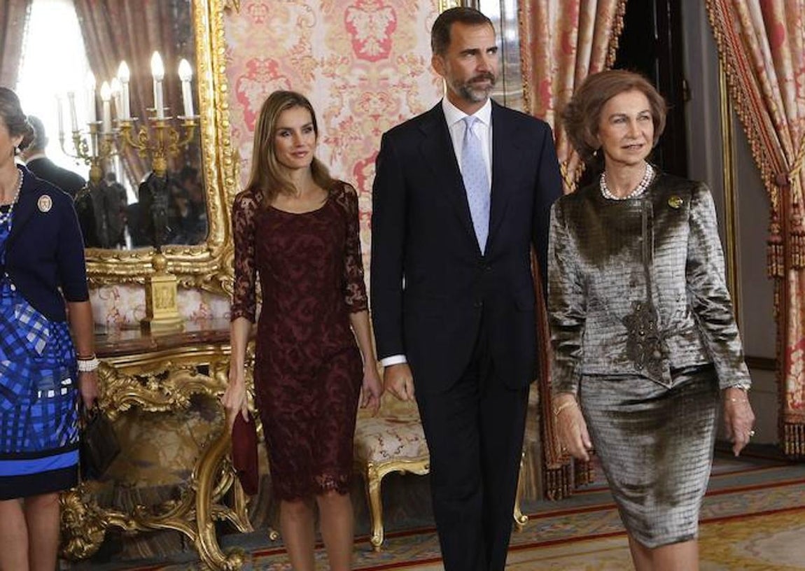La Reina llevó en 2013 vestido burdeos de Felipe Varela con zapatos de Magrit y chaqueta rosa. 