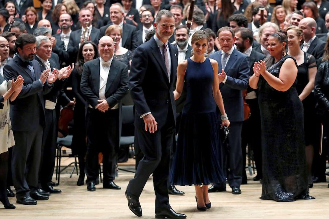 A su entrada al salón de conciertos, el público recibió a los Reyes con un aplauso que solo cesó, a los treinta segundos, porque la orquesta empezó a interpretar el Himno Nacional y se hizo silencio. 