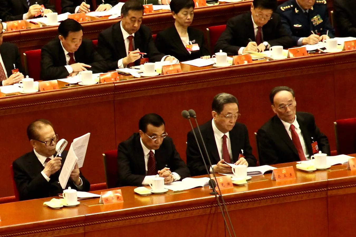 El expresidente Jiang Zemin, de 91 años, lee con una lupa el discurso de inauguración del XIX Congreso del Partido Comunista chino, junto al primer ministro, Li Keqiang, y la cúpula del régimen. 