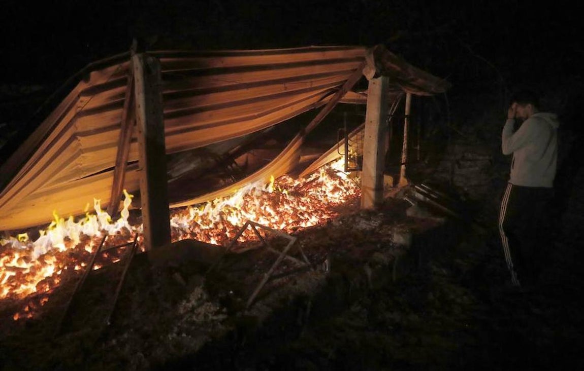 Un vecino observa su almacén calcinado en Chandebrito, Galicia (España). 