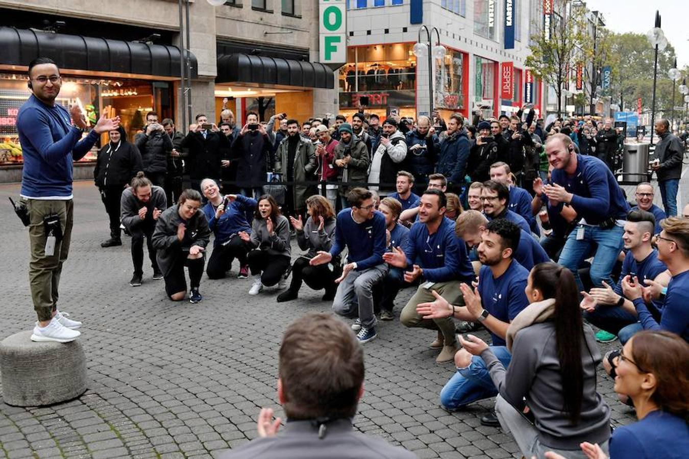 Empleados de Apple entretienen a una multitud que espera en Colonia, Alemania. 