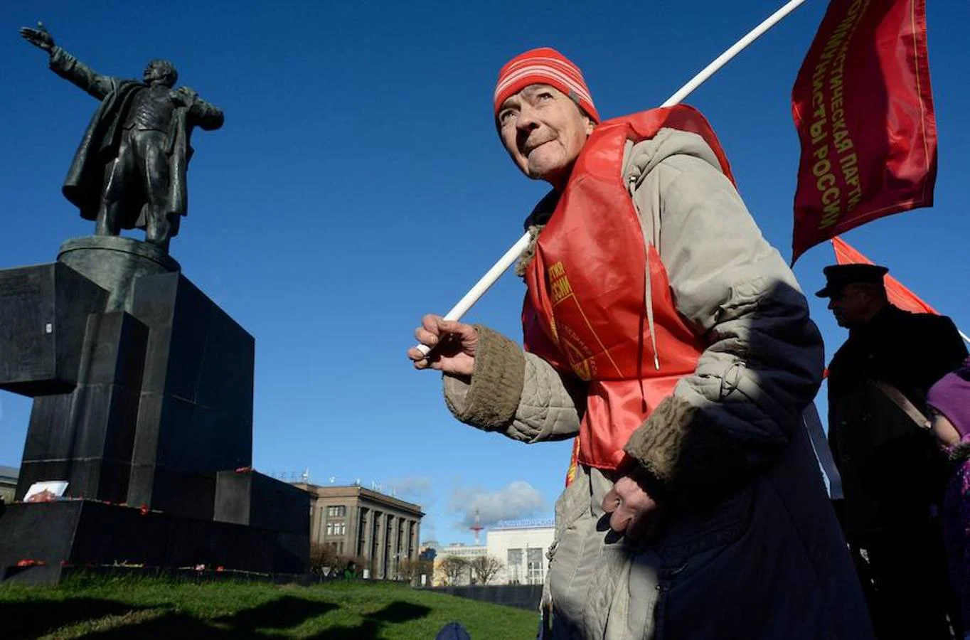 Uno de los manifestantes, en San Petersburgo, es fotografiado con una bandera y junto a un momento en memoria de Vladímir Lenin. 