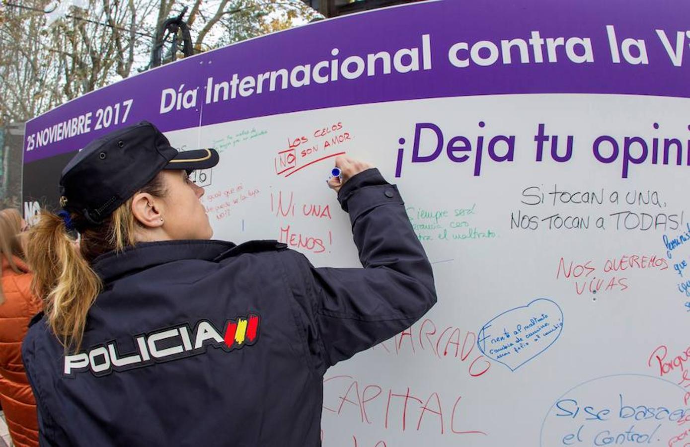 Una policía nacional firma el muro donde los asistentes plasmaban sus opiniones. Gijón. 