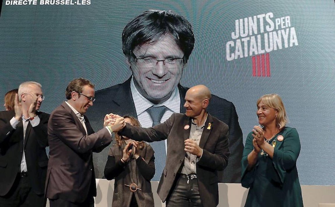 El candidato y exconsejero cesado Josep Rull (2i) saludaba a Xavier Quintillá (2d) en el acto de campaña de Junts per Catalunya celebrado este lunes en Lérida, en el que participó por videoconferencia el expresidente Carles Puigdemont. 
