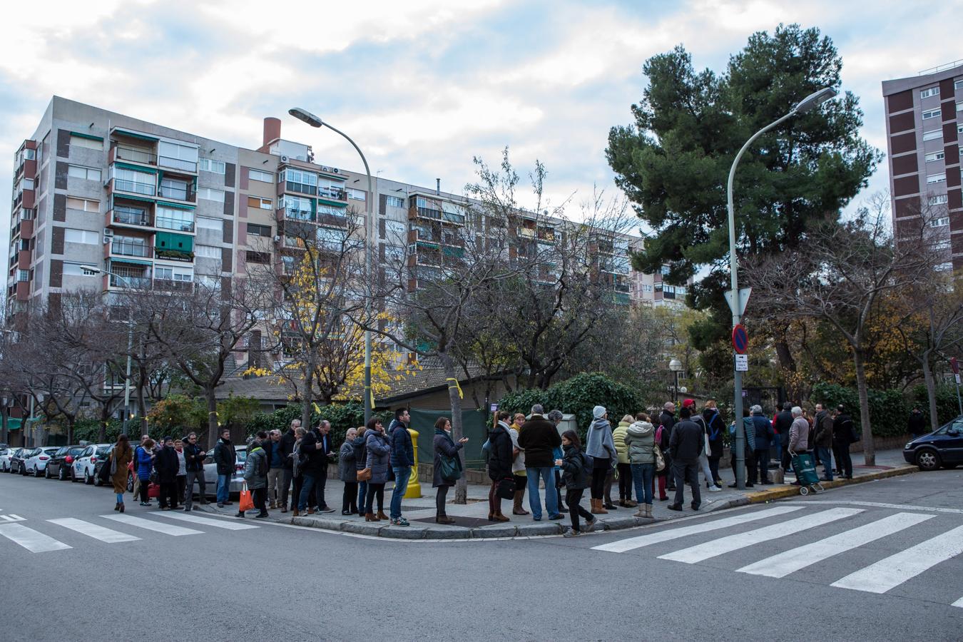 Una fila de ciudadanos esperan para votar en el exterior del colegio electoral Narcís Monturió de Barcelona. 