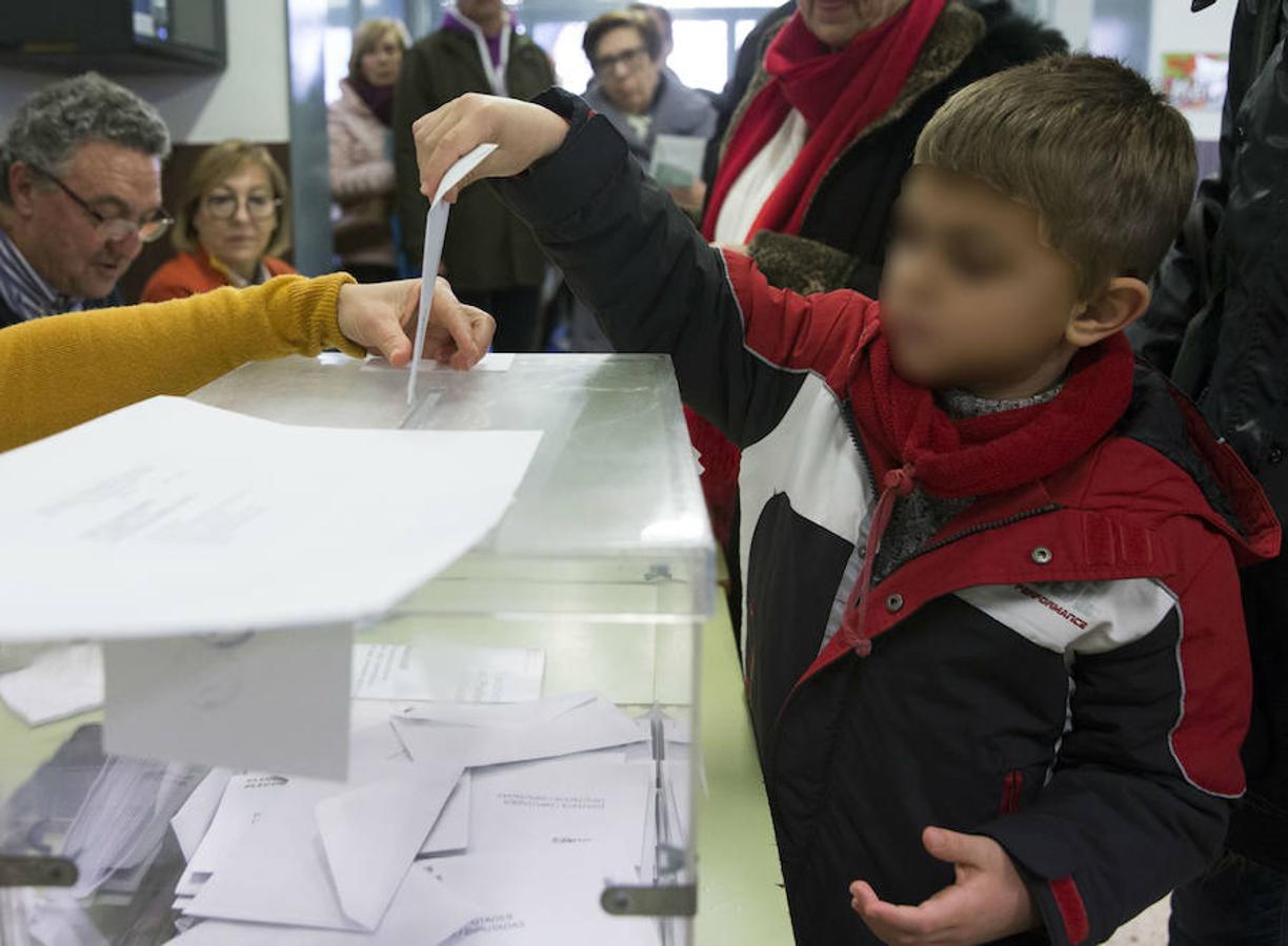 Un niño introduce un sobre en la urna de un colegio electoral de Barcelona. 
