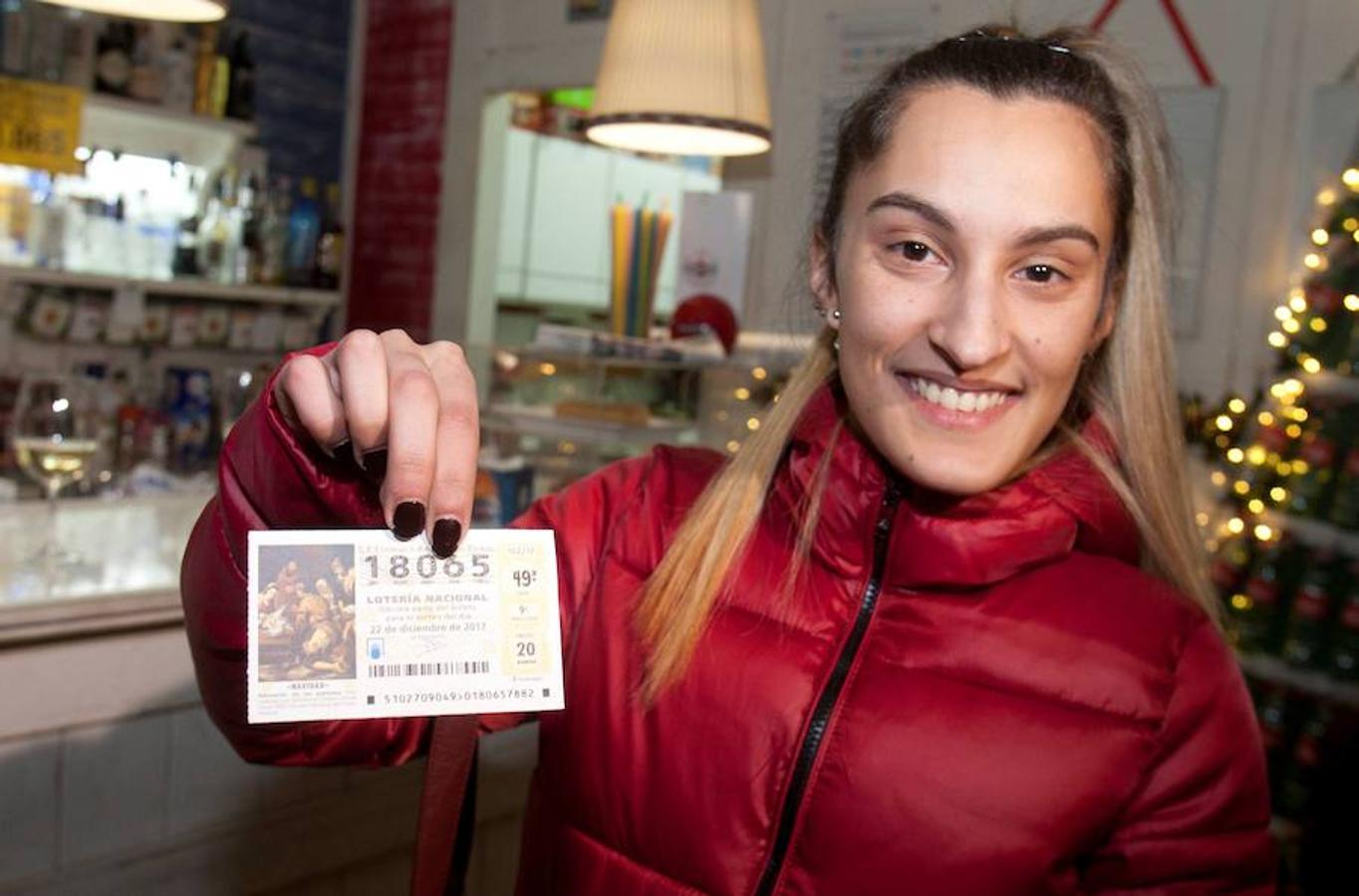 El número 18065, premiado con un millón de euros en el Sorteo Extraordinario de la Lotería de Navidad se ha repartido en la cafetería «Lo que queda del Día de Salvaterra do Miño», en Pontevedra. En la imagen, una agraciada muestra el décimo premiado. 