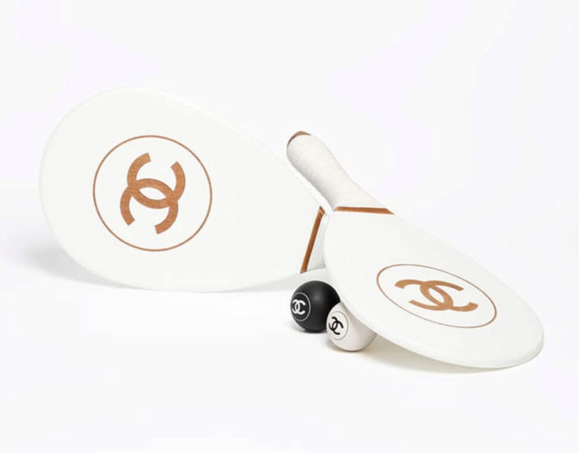 Chanel. Las palas más lujosas y polémicas del verano de 2017. La casa parisina lanzó diferentes artículos relacionados con el deporte en su colección primavera - verano. Este juego de palas y pelotas costaba 3.170 euros, y no fue el único artículo que fascinó a los amantes -y detractores- del lujo, también sacó un set de pelotas de golf, dos modelos de raquetas de tenis y de bádminton y una tabla de surf cuyo precio nada tenía que envidiar al carísimo boomerang con el que escandalizaron a sus seguidores la temporada pasada