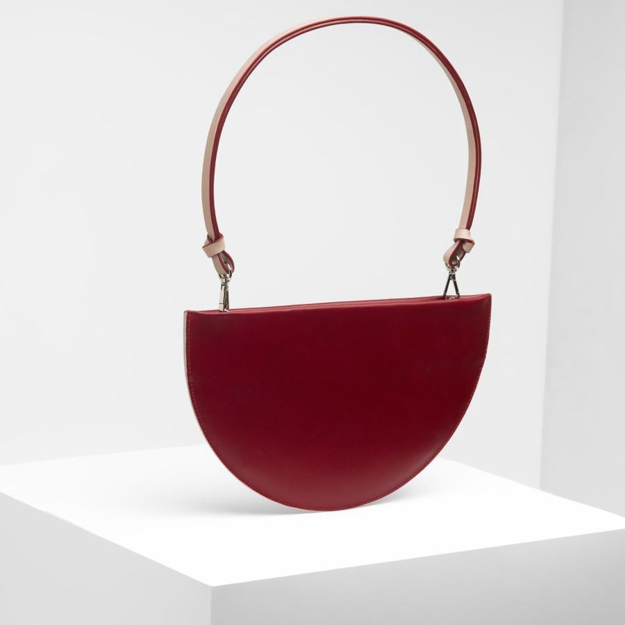 Malababa. Modelo Mini metrica con forma de semicírculo en color burdeos. (Precio: De 200 a 140 euros)