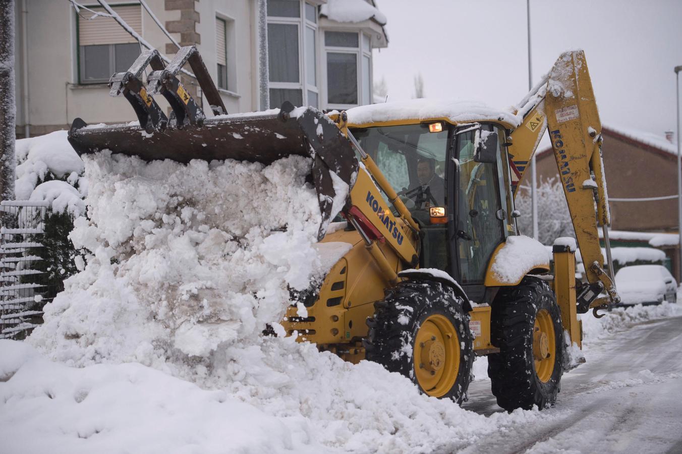 Una excavadora limpia una calle de nieve en la localidad cántabra de Reinosa. 