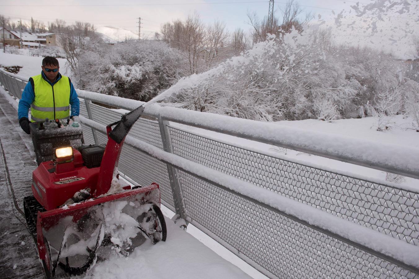 Un hombre limpia de nieve una calle con ayuda de una máquina, hoy en la localidad cántabra de Reinosa. 