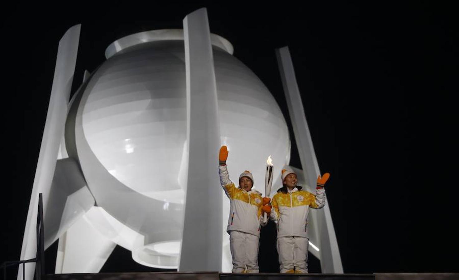 Dos atletas han dado el último relevo de la antorcha olímpica antes de encender el pebetero. 
