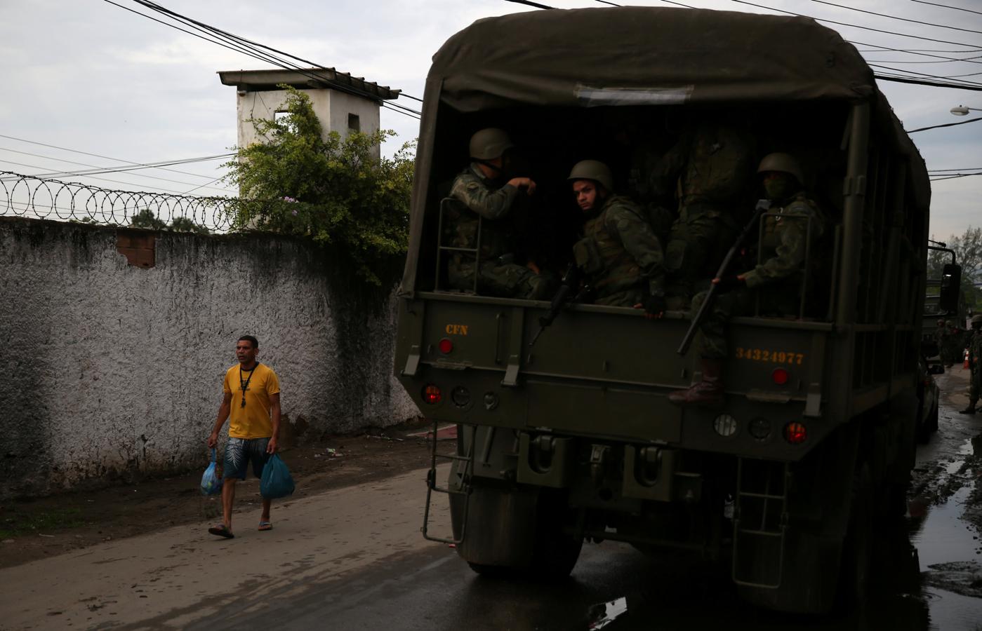 Un furgón militar pasa junto a un habitante de la favela carioca de Kelson. 