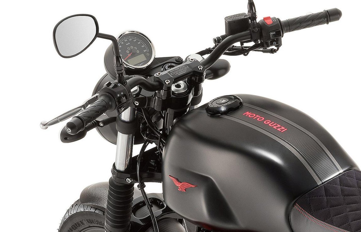 Moto Guzzi V7 III Carbon. La nueva versión se ha denominado «Carbon» y es un claro ejemplo de lo personalizables que son este tipo de motocicletas. La V7 Carbon es una edición limitada y numerada, que añade elementos de fibra de carbono en los guardabarros acortados y lisos, y en las tapas laterales del carenado. Otro de los elementos diferenciadores de la V7 Carbon es un asiento especifico con tapizado en piel de Alcántara, que según dice el fabricante repele el agua. En este asiento podemos ver bordados con hilo rojo en formato rombo, al más puro estilo clásico de los años 60. En la parte trasera del asiento encontramos bordado «Moto Guzzi»
