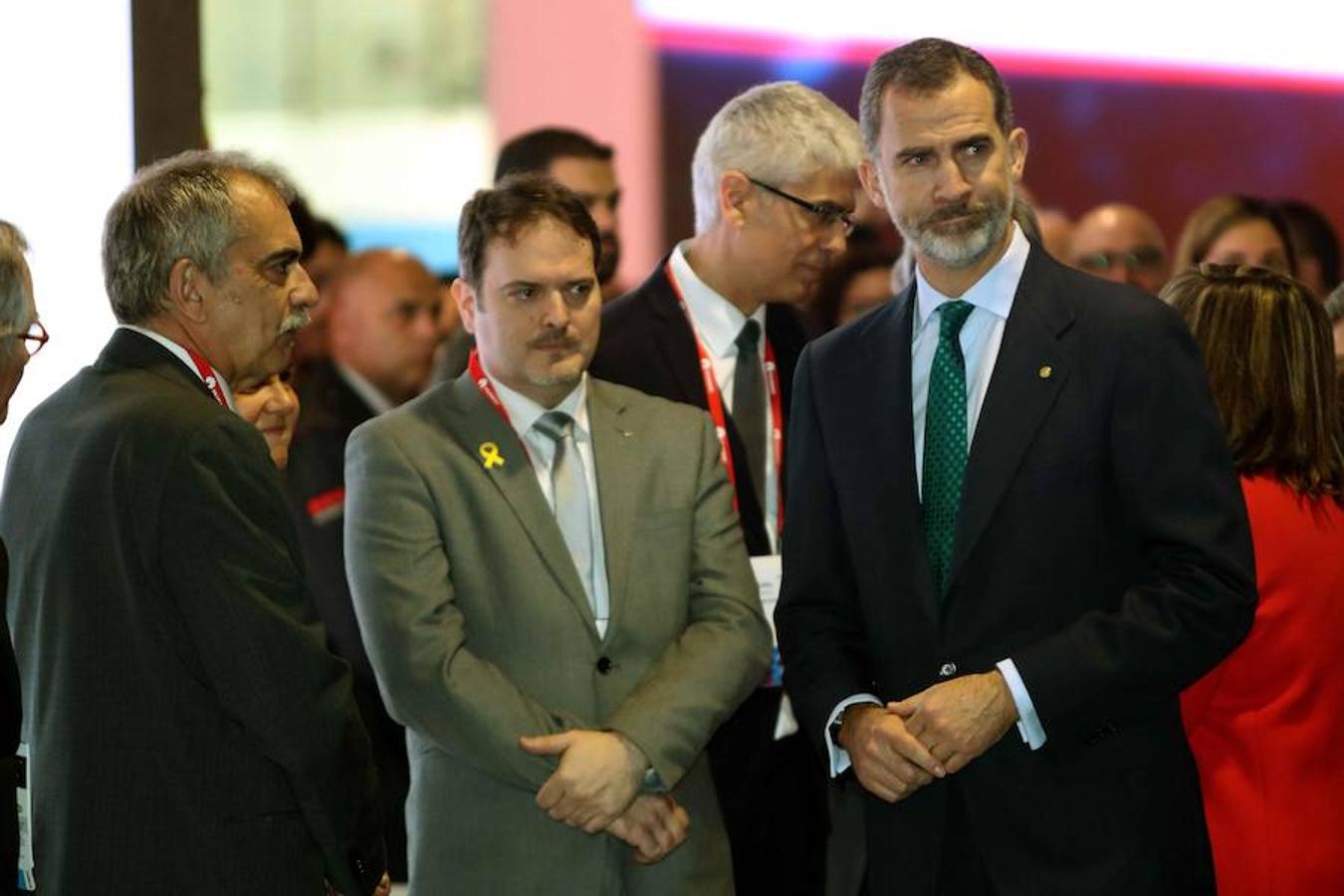 El Rey Felipe VI, junto al secretario general de empresa Pau Villori y el consejero delegado de Acció Joan Romero hablan en el pabellón de la Generalitat. 
