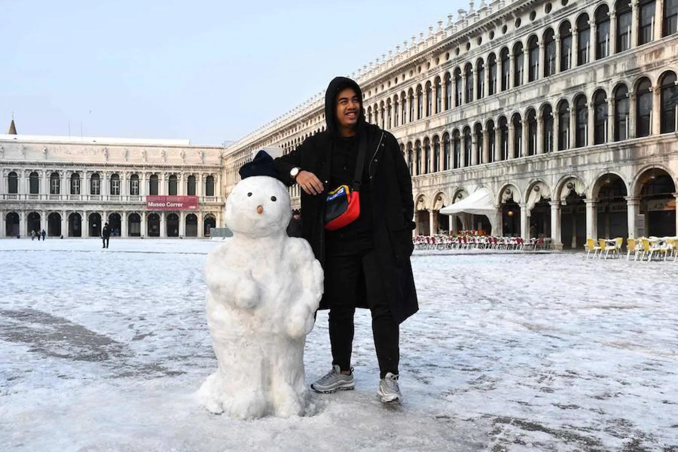 Un turista posa junto a un muñeco de nieve en Venecia.. 