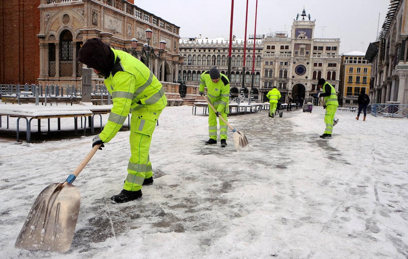 Trabajadores quitan nieve de la turística Plaza de San Marcos de Venecia.. 