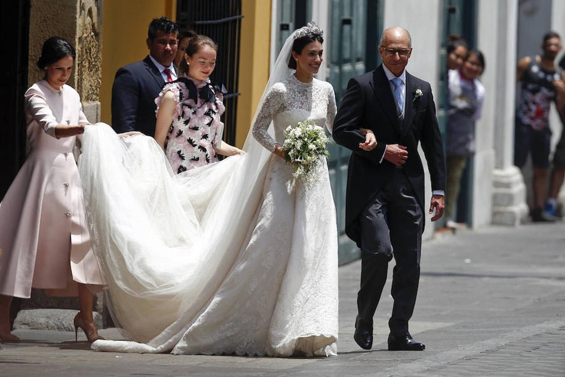 De la tiara iba sujeto un largo velo del que se ocupaban sus damas de honor. 