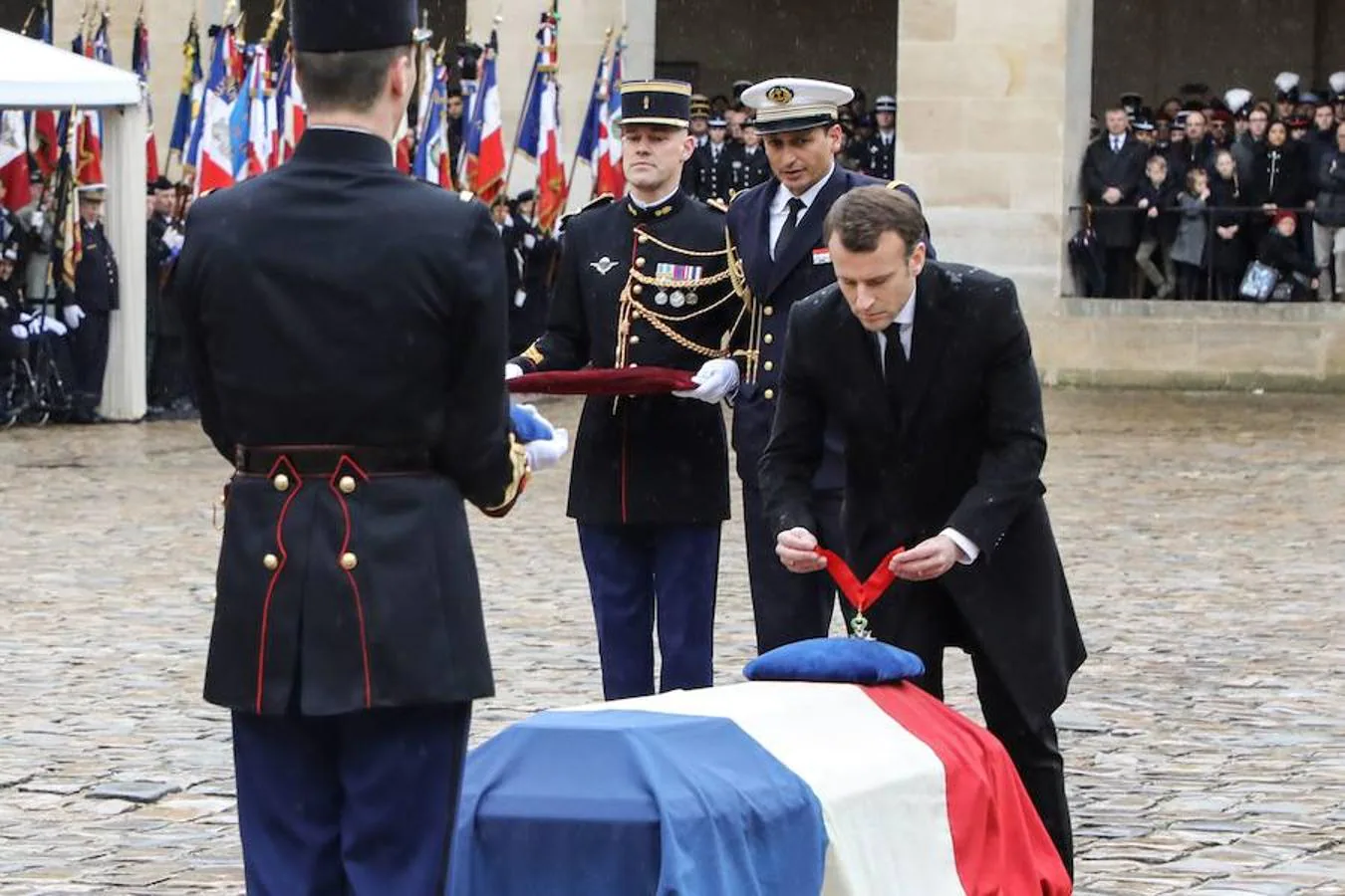 El presidente francés, Emmanuel Macron, coloca la insignia de la Legión de Honor durante la ceremonia de Estado celebrada en la Explanada de los Inválidos, en París, este miércoles. 