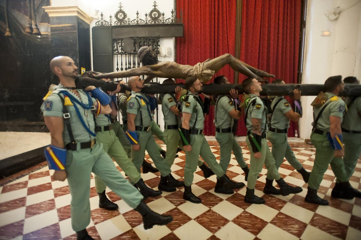 Los legionarios trasladan el Cristo de la Buena Muerte, en imágenes
