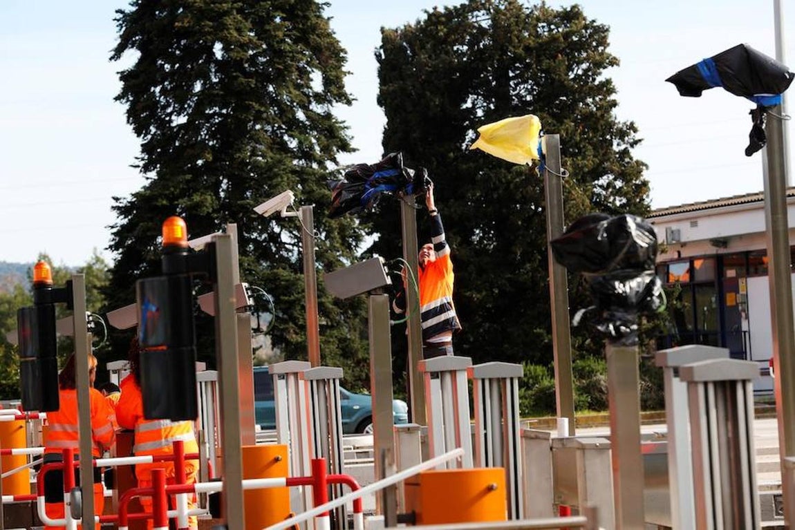 Operarios de autopistas trabajan en quitar las bolsas en las cámaras del peaje de la autopista AP-7. 