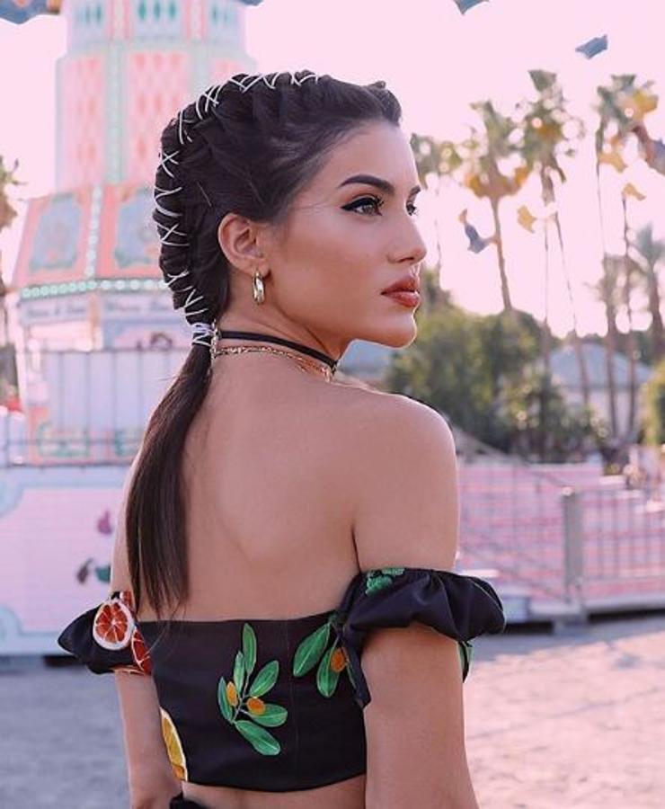 Trenza en tubo. Otro de los peinados que tiene como protagonista a la trenza es el look de Camila Coelho. Un recogido en forma de tubo que va adornado con un listón en tono blanco. El resto de cabello le cae como una coleta lisa.