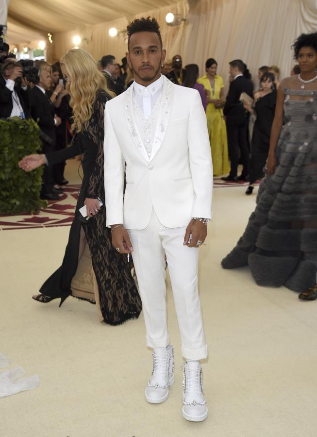 Lewis Hamilton. El piloto de Fórmula 1 apareció de blanco impoluto de pies a cabeza con esmoquin ocn las solapas en raso bordado de Tommy Hilfiger y botas de Loriblu.