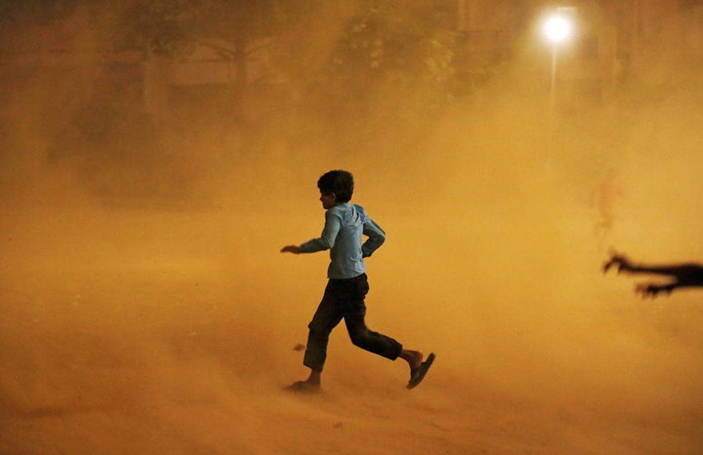 Un niño corre durante la tormenta de arena en Nueva Delhi. 