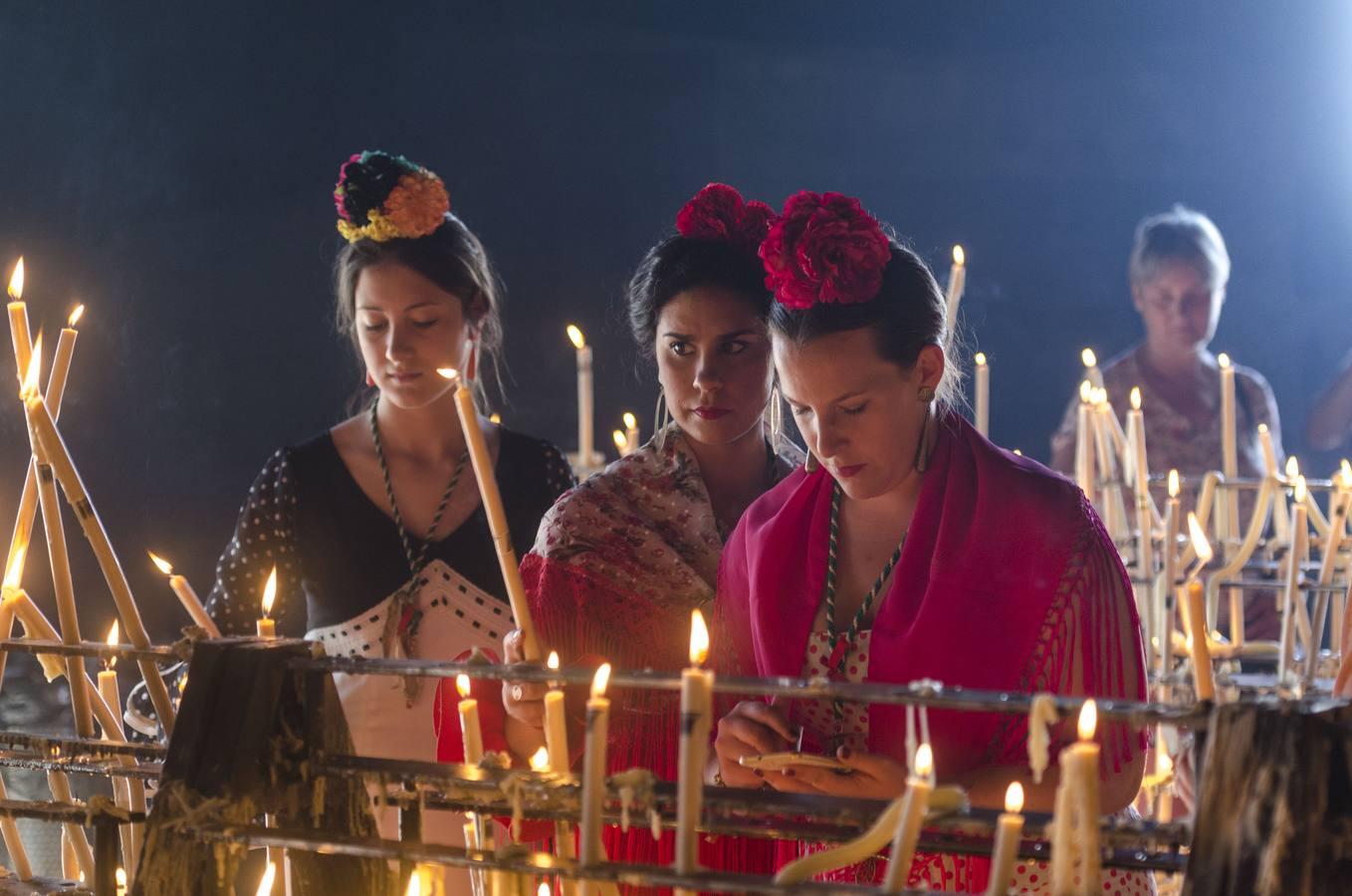 Unas flamencas le ponen velas a la Virgen del Rocío en su capilla votiva