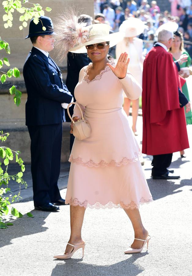 Ophra Winfrey ha elegido para este día un conjunto de falda y cuerpo en color rosa palo y un increible sombrero en color hueso. 