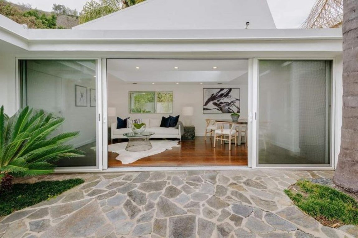 Paredes de cristal. Las estancias de la casa están abiertas al exterior, las puertas correderas se abren al jardín