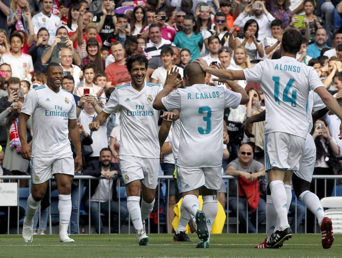 Roberto Carlos felicita a Raúl por su gol en presencia de más jugadores. 