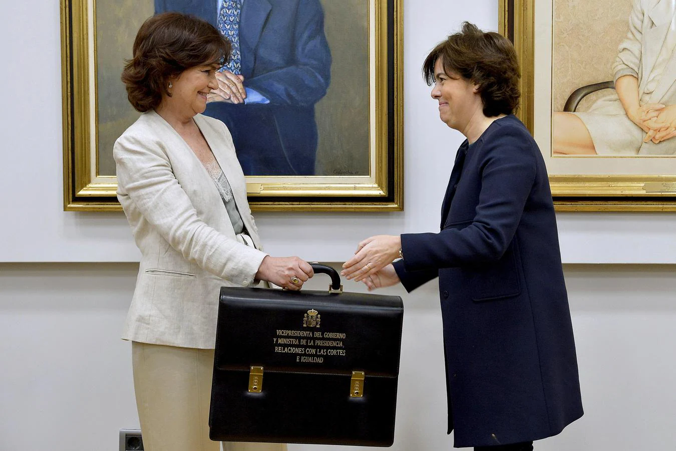 La vicepresidenta del gobierno y ministra de Presidencia e Igualdad Carmen Calvo, recibe la cartera de la exvicepresidenta Soraya Sáez de Santamaría (derecha), en el Palacio de la Moncloa en Madrid. 