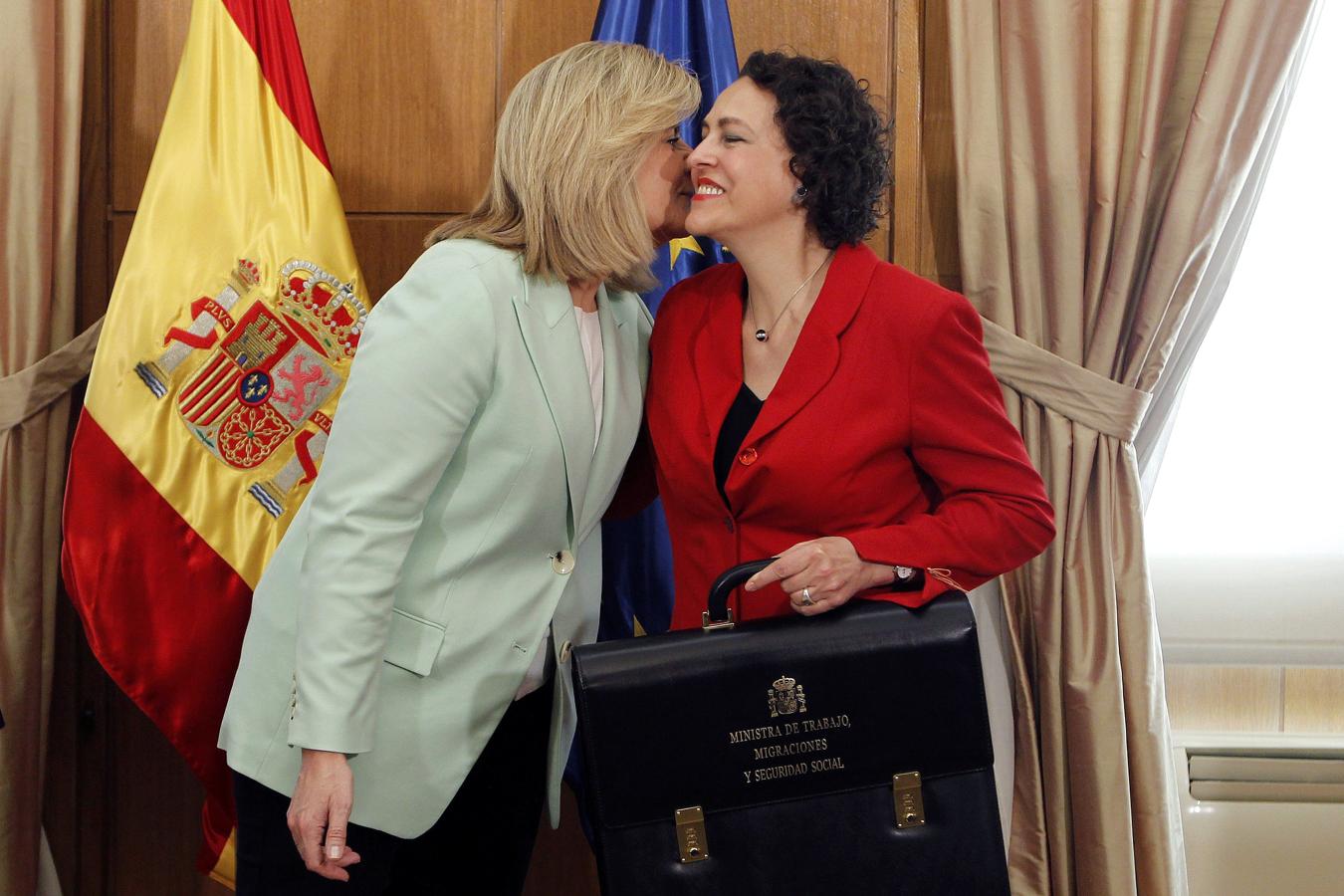 La nueva ministra de Trabajo, Migraciones y Seguridad Social, Magdalena Valerio (derecha), con la cartera que ha recibido de su antecesora, Fátima Báñez. 