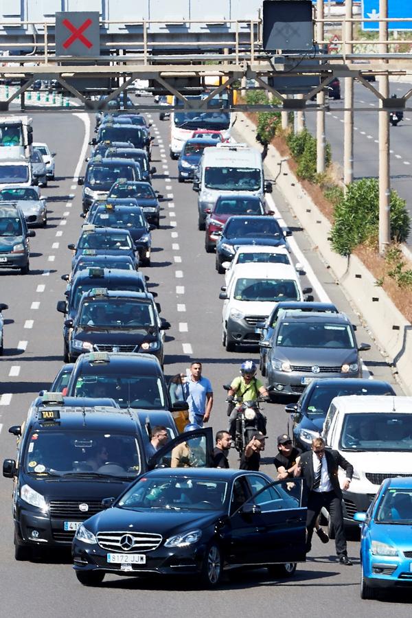 Taxistas increpan al conductor de un vehículo VTC en Barcelona. 