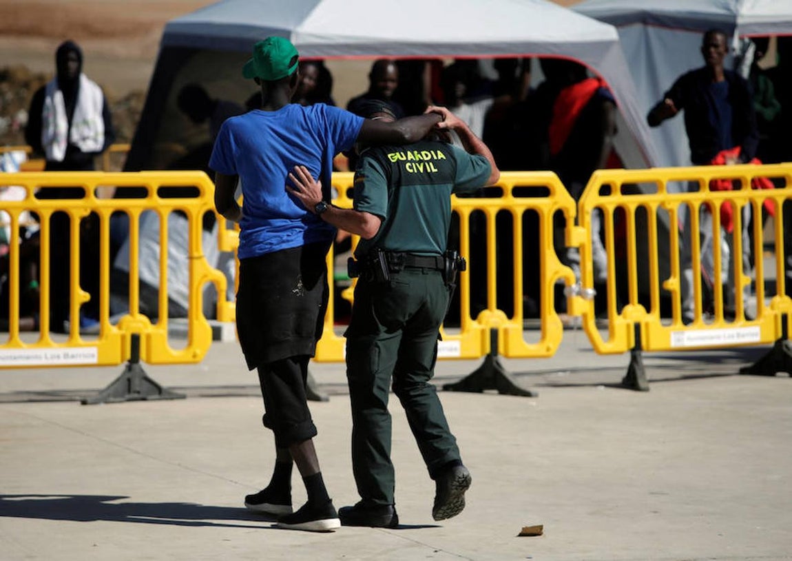 Uno de los guardias civiles –que cuida y vigila a las personas que llegan en patera a las costas de Cádiz y son trasladadas al pabellón «Antonio Gavira», en el municipio Los Barrios, cerca de Algeciras– aparta el brazo del inmigrante que se abrazaba a su cuello.. 